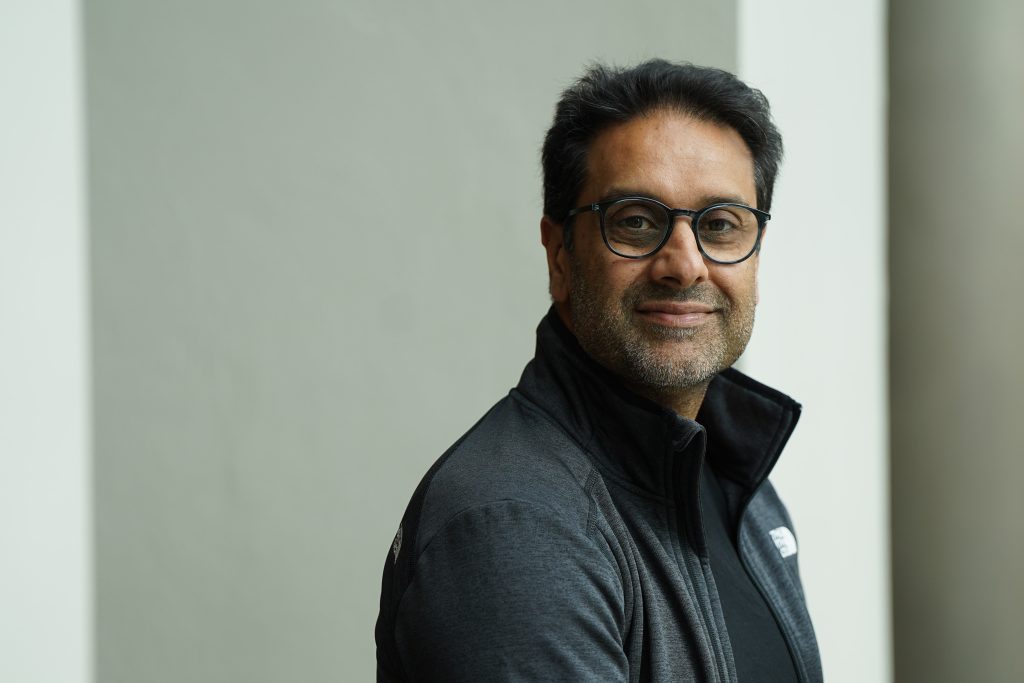 Man facing camera with plain background.